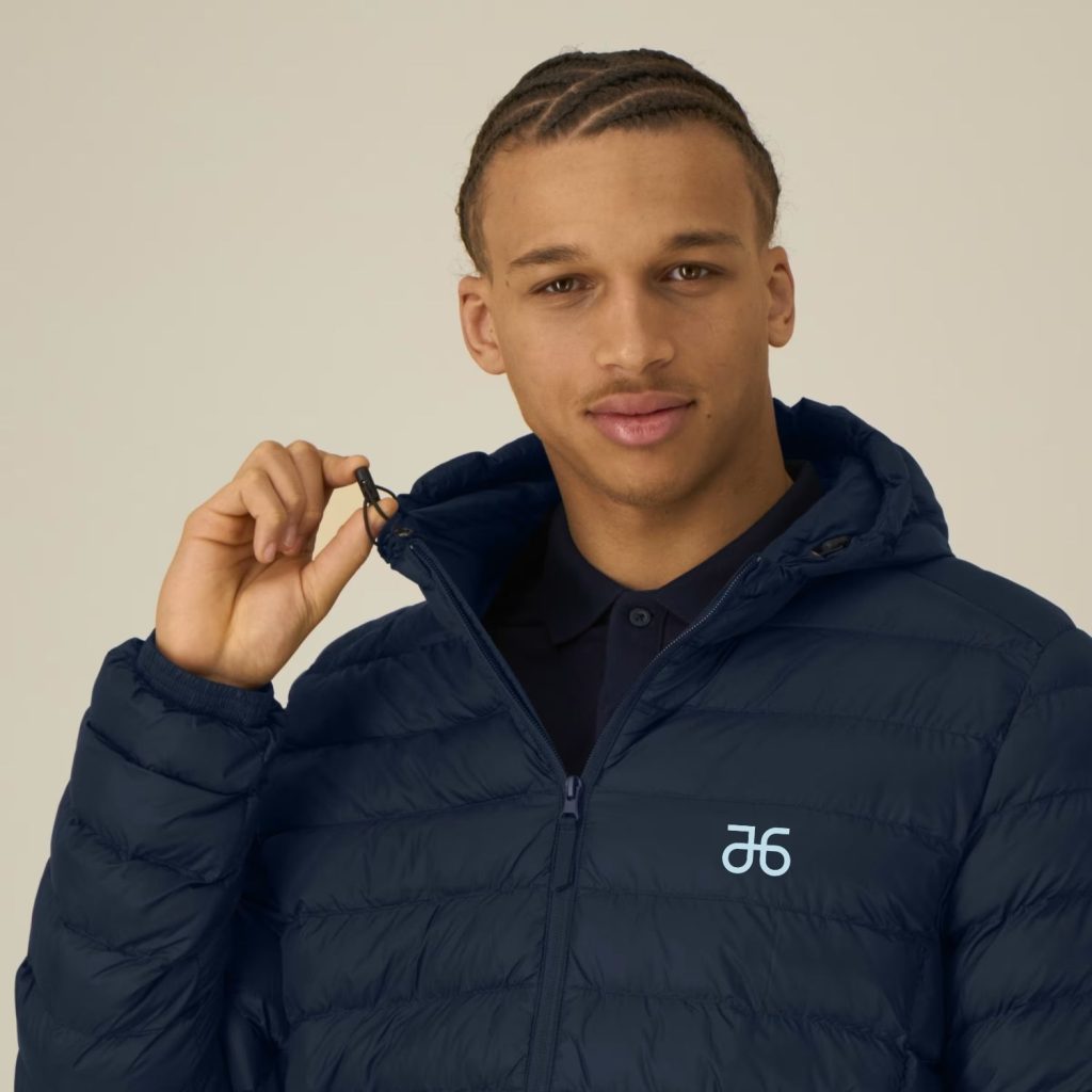 Ein Mann trägt die Atruvia Winterjacke mit Kapuze (KI-generiert)