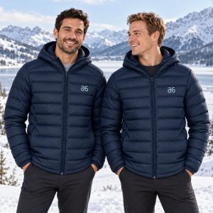 Zwei Männer tragen die navyblaue Atruvia Winterjacke mit Kapuze vor verschneiter Berglandschaft (Symbolbild, KI-generiert)